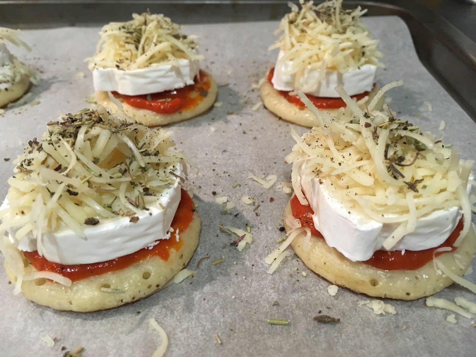 Mini blinis gratinés au chèvre et à la tomate